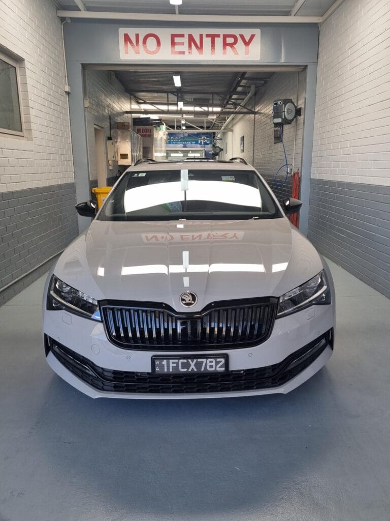 White Skoda parked front-on inside West Perth Panel's workshop entrance